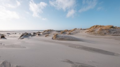 Strand met duinen en een blauwe lucht 